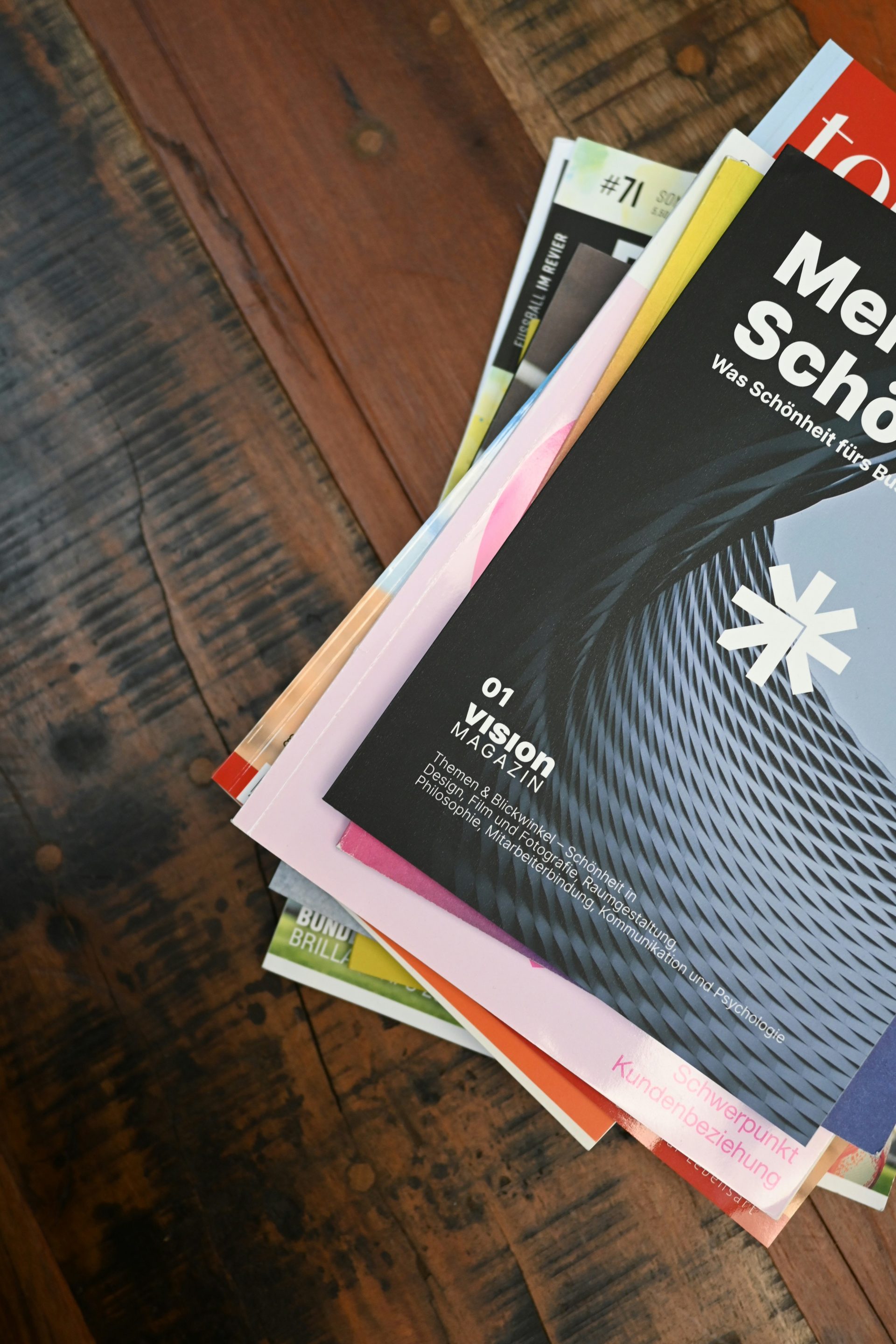 Ein Stapel Bücher liegt auf einem Holztisch.